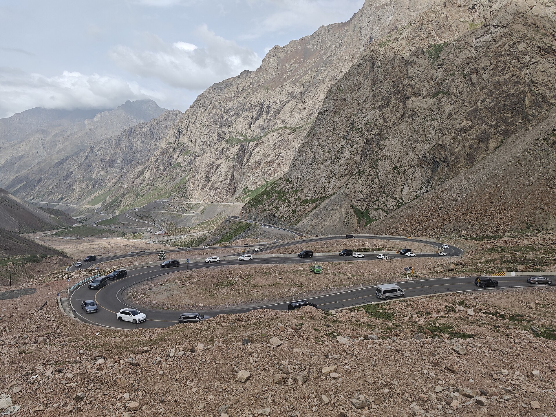 A winding mountain road bending through the green Tianshan mountains on the Duku Highway
